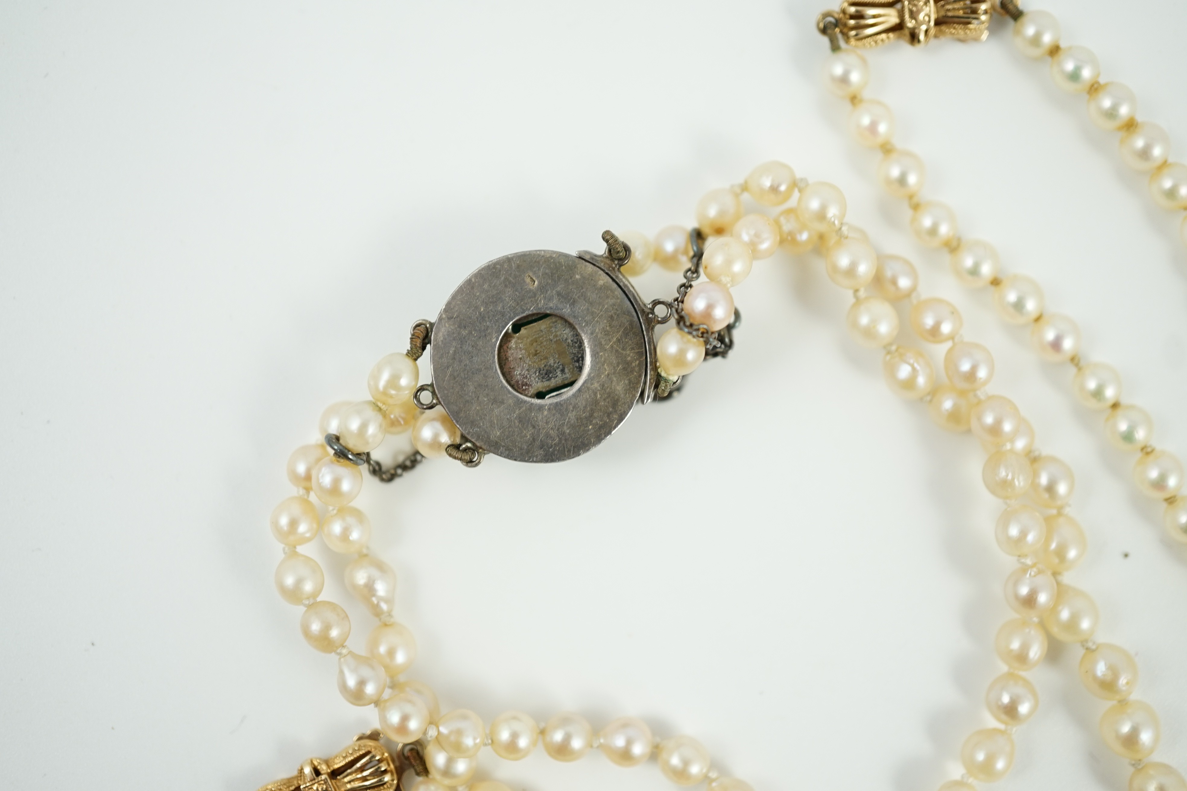 A twin strand graduated cultured pearl necklace, with white metal and two colour paste set clasp, 40cm, a single strand cultured pearl necklace, with 9ct gold clasp and a similar bracelet.